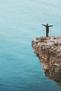 Happy traveler standing on cliff above sea hands raised Travel Lifestyle success motivation concept Royalty Free Stock Photo