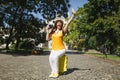 Happy traveler tourist woman sitting on suitcase hold retro vintage photo camera waving hand for greeting, meeting Royalty Free Stock Photo