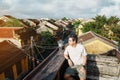 Happy traveler traveling at Hoi An ancient town in Vietnam, man sightseeing view at rooftop. landmark and popular for tourist Royalty Free Stock Photo