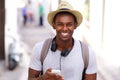 Happy traveler walking in town with mobile phone Royalty Free Stock Photo