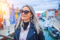 Happy traveler woman having fun near colorful houses on Burano island in Venetian lagoon. Travel and vacation in Italy Royalty Free Stock Photo