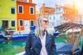 Happy traveler woman having fun near colorful houses on Burano island in Venetian lagoon. Travel and vacation in Italy Royalty Free Stock Photo