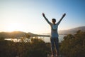 Happy traveler, woman with open arms stands on the rock Royalty Free Stock Photo