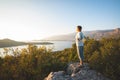 Happy traveler, woman with open arms stands on the rock Royalty Free Stock Photo