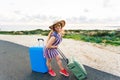 Happy traveler woman with suitcase on the road and laughs. Concept of travel, journey, trip Royalty Free Stock Photo