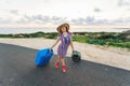 Happy traveler woman with suitcase on the road and laughs. Concept of travel, journey, trip Royalty Free Stock Photo