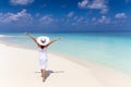 Happy traveler woman in white dress enjoys her tropical beach vacation Royalty Free Stock Photo