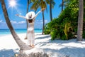 Woman stands on a tropical beach and enjoys her vacation, Maldives Royalty Free Stock Photo