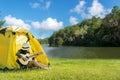 Happy traveler women on vacation camping with tents playing guitar in the forest near river. Royalty Free Stock Photo