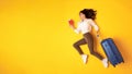 Happy Traveler Young Lady Running With Suticase On Yellow Background