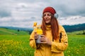 Happy traveler young woman resting in the mountains and drinking tea from thermos at sunset in spring or summer season. Royalty Free Stock Photo