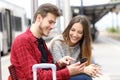 Happy travelers booking hotel in a train station