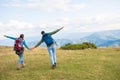 Happy travelers couple conquered top of mountain, raises hands up Royalty Free Stock Photo