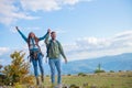 Happy travelers couple conquered top of mountain, raises hands up Royalty Free Stock Photo