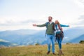 Happy travelers couple conquered top of mountain, raises hands up Royalty Free Stock Photo