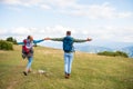 Happy travelers couple conquered top of mountain, raises hands up Royalty Free Stock Photo