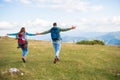 Happy travelers couple conquered top of mountain, raises hands up Royalty Free Stock Photo