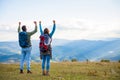 Happy travelers couple conquered top of mountain, raises hands up Royalty Free Stock Photo