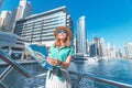 traveller girl with a map on a cruise ship at the Marina port in Dubai. Travel destinations and transport concept