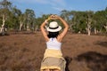 Happy traveller woman standing and showing hands heart shape at nature,Back view