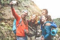 Happy trekkers making selfie instagram story with smartphone - Sporty people having fun with technology trends in nature - Healthy Royalty Free Stock Photo