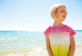 Happy trendy child in colorful shirt on beach looking aside