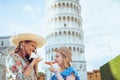 Happy trendy family with pizza near Leaning Tower in Pisa,