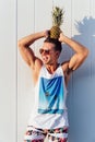 Handsome man holds a pineapple on his head, standing outdoors Royalty Free Stock Photo