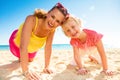 Happy trendy mother and daughter in colorful clothes on beach