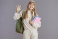 happy trendy school girl in beige tracksuit handwaving Royalty Free Stock Photo