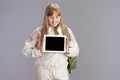 happy trendy teen girl in beige tracksuit showing tablet PC Royalty Free Stock Photo