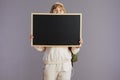 happy trendy teenager girl with backpack showing blank board Royalty Free Stock Photo