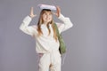 happy trendy teenager girl in beige tracksuit with backpack Royalty Free Stock Photo