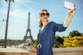 Happy trendy tourist woman taking selfie with phone