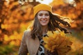 Happy trendy woman in brown coat and yellow hat Royalty Free Stock Photo