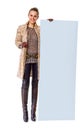 Happy trendy woman in winter coat on white showing blank board Royalty Free Stock Photo