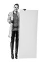 Happy trendy woman in winter coat on white showing blank board Royalty Free Stock Photo
