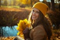 happy trendy 40 years old woman in brown coat and hat sitting Royalty Free Stock Photo