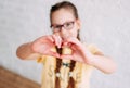 Happy tweens girl in yellow t-shirt making heart by hands on the white wall background, selective focus Royalty Free Stock Photo