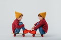 Happy twin boys sitting on skateboards in studio