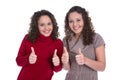 Happy twin girls making thumb up gesture over white background.