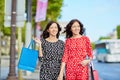 Happy twin sisters doing shopping on holidays in France Royalty Free Stock Photo