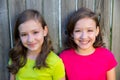 Happy twin sisters smiling on wood backyard fence