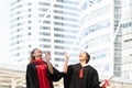 Happy two Asian young beautiful graduate female students with master and bachelor degree throwing cap to the sky after graduation Royalty Free Stock Photo