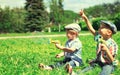 Happy two boys children playing together with toys and blowing soap bubbles in the park on summer day