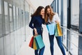 Happy two caucasian women are doing shopping together at the mall center. Two young women are walking with shopping bags at mall Royalty Free Stock Photo