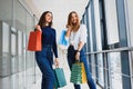 Happy two caucasian women are doing shopping together at the mall center. Two young women are walking with shopping bags at mall Royalty Free Stock Photo