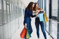 Happy two caucasian women are doing shopping together at the mall center. Two young women are walking with shopping bags at mall Royalty Free Stock Photo