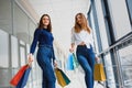 Happy two caucasian women are doing shopping together at the mall center. Two young women are walking with shopping bags at mall Royalty Free Stock Photo