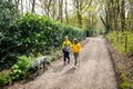 Happy two children running after a dog together in park. Boy and girl take care of pet. Family outdoors Royalty Free Stock Photo